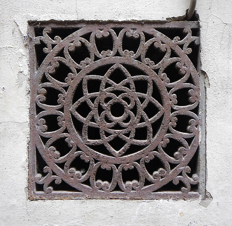 rusty sewer cover with ornaments