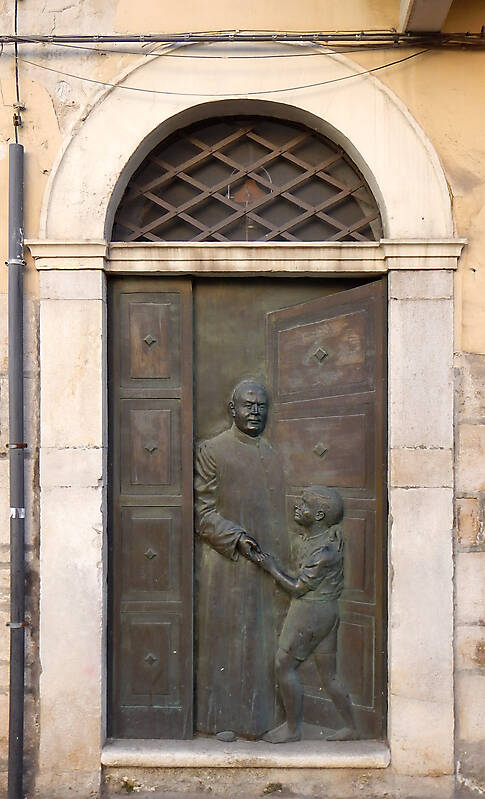 bronze door with priest and kid