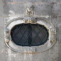 rounded old medieval window with grate 12