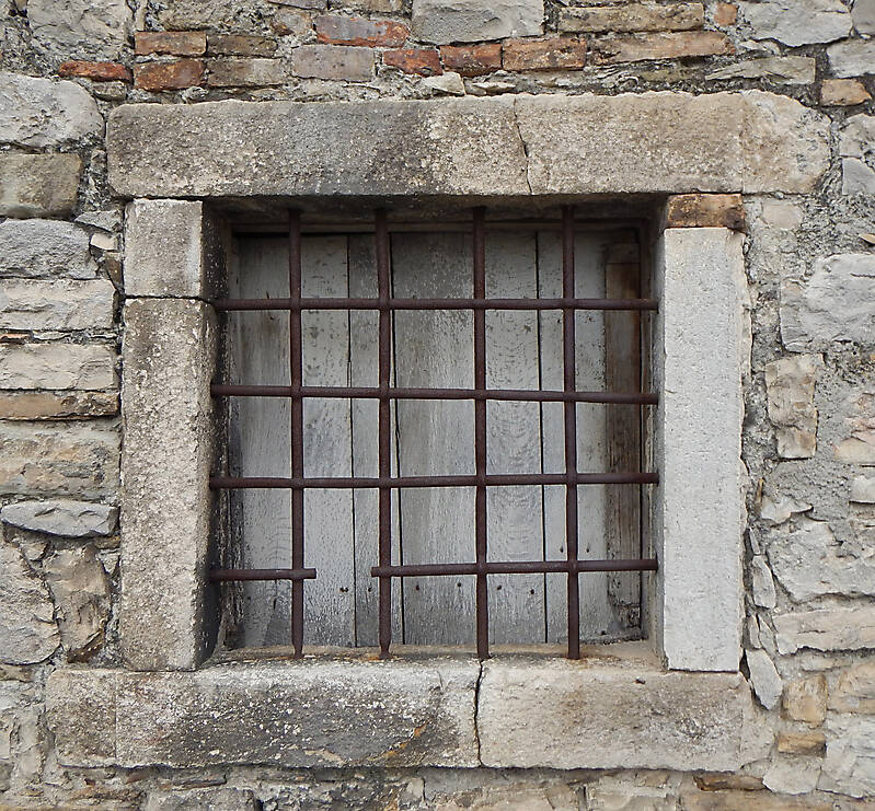 old medieval window stone and rusty cage